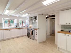 a kitchen with white cabinets and an open door at Canal View House - Uk39363 in Swafield