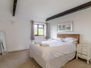 a bedroom with a large white bed and a window at Canal View House - Uk39363 in Swafield