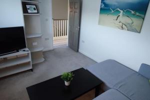 un soggiorno con divano e tavolo di Comfortable 1 Bed flat with Air Con a Borehamwood