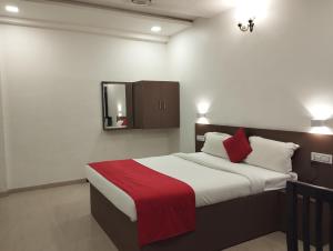 una camera con un letto con una coperta rossa di Fortview Resort a Daulatābād