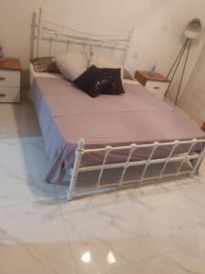 a bed with a metal frame in a bedroom at 300 years old apartment with a lot of character in Qormi
