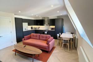 a living room with a pink couch and a table at Apartments in the heart of Richmond, London in Richmond upon Thames