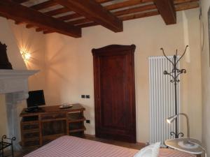 1 dormitorio con 1 cama y puerta de madera en B&B Piazza del Papa, en SantʼAngelo in Vado