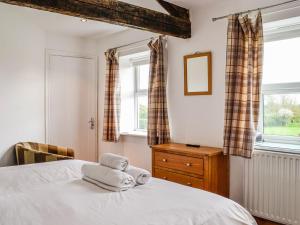 1 dormitorio con 1 cama con toallas en Mount Farm - The Stable en Harker