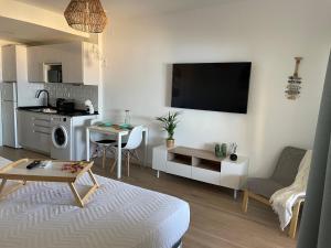 a living room with a couch and a kitchen with a table at Benalbeach Smart Suite in Benalmádena