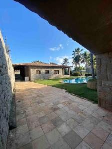 a brick house with a swimming pool in a yard at Casa de Praia no Porto das Dunas in Aquiraz