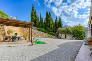 un patio con mesa, sillas y árboles en Cortijo Montes I, en Cómpeta