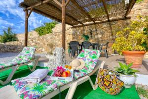 un patio con sillas y una mesa con una bandeja de fruta en Cortijo Montes I, en Cómpeta