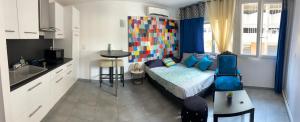 a living room with a bed and a kitchen at Côtéplage in Le Lavandou
