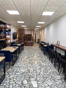 une salle à manger avec des tables et des chaises et un sol en pierre dans l'établissement Lemuju B&B Hotel, à Daxi