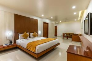 pokój hotelowy z łóżkiem i telewizorem w obiekcie Pai Resort w mieście Belagavi