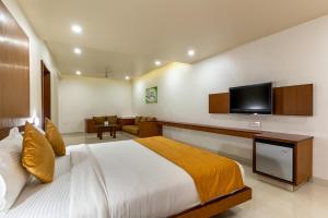 una camera con letto e TV a schermo piatto di Pai Resort a Belgaum