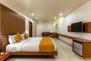 a bedroom with a bed and a flat screen tv at Pai Resort in Belgaum