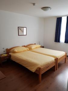 Motel & Aparthotel Brüggli في إيمين: غرفة نوم بسرير كبير مع شراشف صفراء
