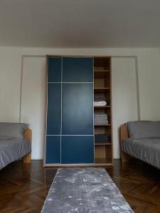 Belgrade centrum في Karaburma: خزانة زرقاء في غرفة مع سريرين