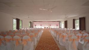 una stanza con file di sedie con archi arancioni di Fortview Resort a Daulatābād