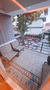 a balcony with a bench and a table and chairs at Vila Casablanca - Boutique Hotel & Restaurant in Shkodër