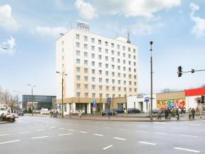 duży biały budynek na rogu ulicy w obiekcie Hotel Petropol w mieście Płock