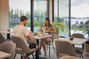 Ein Mann und eine Frau sitzen an einem Tisch in einem Restaurant in der Unterkunft Hotel Vinci in Sirmione