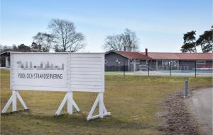 a white sign sitting in the grass in front of a building at Nice Apartment In Frjestaden With Kitchen in Färjestaden