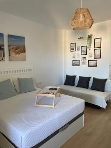 een kamer met twee bedden en een tafel er bovenop bij Benalbeach Smart Suite in Benalmádena