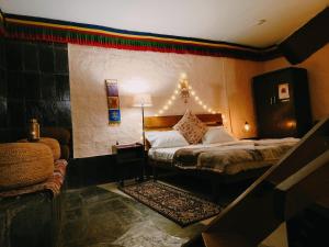 - une chambre avec un lit, une lampe et un canapé dans l'établissement Mud House Cottage & Sauna - McleodGanj, à Dharamshala