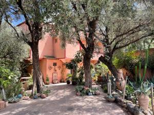 a garden with trees and plants in front of a house at Villa de l'atlas in Tagadirt