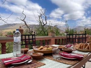 una mesa de picnic con comida y una botella de agua en Villa de l'atlas, 