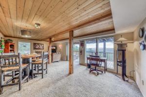 a dining room with a table and chairs and windows at Living the Dream, 3 Bedrooms, Hot Tub, Fireplace, Sleeps 6 in Ruidoso