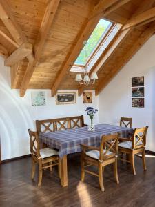 a dining room with a table and chairs and a skylight at Apartmán pod orechom in Drienica