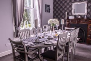 uma sala de jantar com uma mesa e cadeiras e uma lareira em Balyett Farmhouse B&B em Stranraer