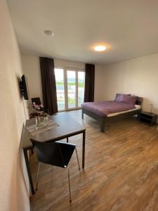 エメンにあるMotel & Aparthotel Brüggliのベッド、デスク、テーブルが備わる客室です。