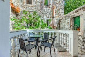 - Balcón con sillas, mesa y sombrilla en Old stone house St Lawrence in the heart of Sibenik's old town en Šibenik