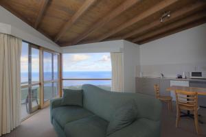 a living room with a blue couch and a table at Chris's Beacon Point Restaurant & Villas in Apollo Bay