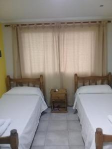 1 dormitorio con 2 camas y mesita de noche entre ellas en San Rafael Ciudad, en San Rafael
