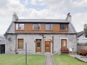 a stone house with wooden doors and a yard at Toab - Uk5662 in Aberdeen