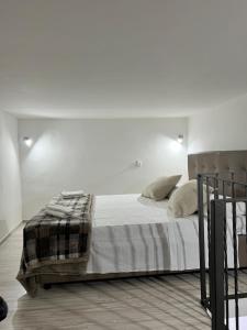 a white bedroom with a bed with white sheets and pillows at AGE Chiaia in Naples