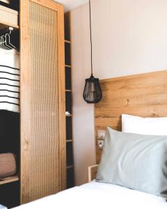 a bedroom with a white bed with a wooden headboard at Le Valserine - Camping éco responsable in Chézery-Forens