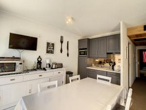 eine Küche mit einem weißen Tisch und einer weißen Arbeitsplatte in der Unterkunft Appartement moderne 3* 8 pers, 46 m², Sud, proche pistes - FR-1-416-78 in La Toussuire