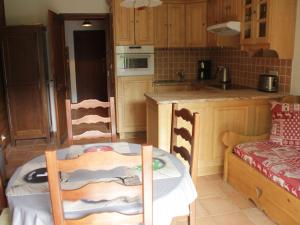 uma cozinha com uma mesa e uma mesa e cadeiras em Studio Châtel, 1 pièce, 4 personnes - FR-1-200-228 em Châtel