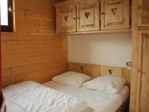 uma cama num quarto de madeira com duas almofadas em Studio Châtel, 1 pièce, 4 personnes - FR-1-200-172 em Châtel