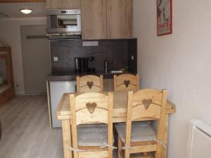 uma cozinha com uma mesa de madeira e 2 cadeiras em Studio Châtel, 1 pièce, 4 personnes - FR-1-200-172 em Châtel