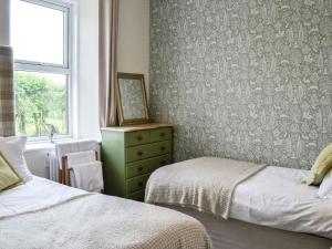 um quarto com 2 camas e uma janela em Bogrie Country Cottage em Canonbie