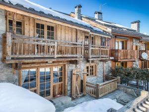 a log home with a deck on the side of it at Chalet Traditionnel à Méribel avec Jacuzzi, Sauna et Accès Direct aux Pistes - FR-1-566-23 in Les Allues