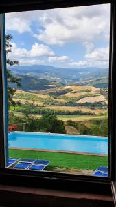 a view of a swimming pool from a window at B&B Marcantonio Country House in Sogliano al Rubicone