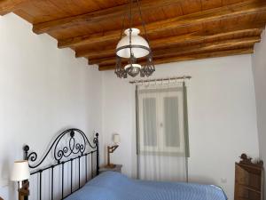 a bedroom with a blue bed and a wooden ceiling at Kalderimi Big Blue Cyclades Syros in Vári