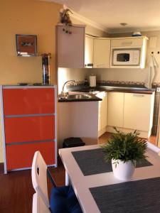 cocina con armarios blancos y nevera roja en Apartamento Vistamar, en La Manga del Mar Menor