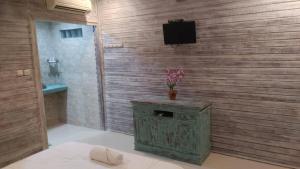 a bathroom with a television on a wooden wall at Sarinah Beach - Bistro & Bungalow in Nusa Penida