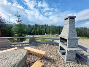 een stenen open haard met een bank en een picknicktafel bij Tatrzanska Polana - Mountain View, Free Parking & WiFi in Zakopane