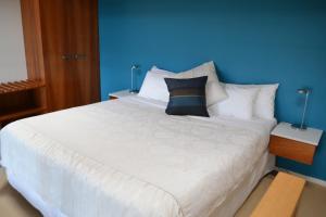 a bed with a white comforter and pillows at Chris's Beacon Point Restaurant & Villas in Apollo Bay